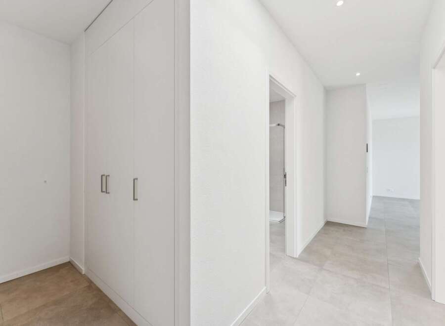 Step into this modern hallway featuring a sleek, built-in wardrobe for ample storage.