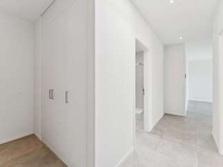 Step into this modern hallway featuring a sleek, built-in wardrobe for ample storage.