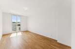 Experience modern living in this bright and airy unfurnished apartment, featuring a spacious living area with abundant natural light streaming through large glass doors.