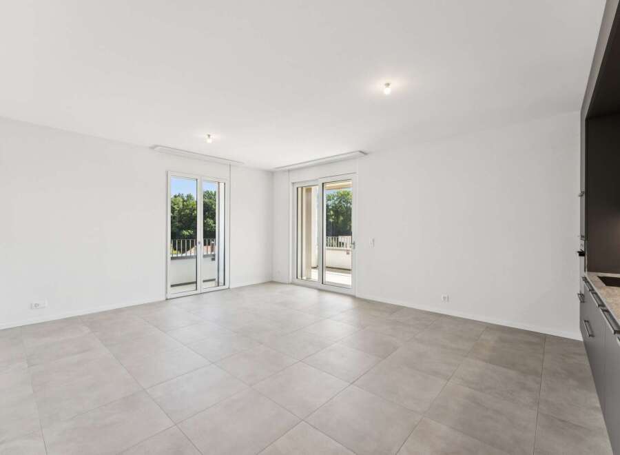 Experience modern living in this spacious, light-filled apartment featuring two sets of sliding glass doors that open onto private balconies, perfect for enjoying the outdoors.