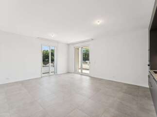 Experience modern living in this spacious, light-filled apartment featuring two sets of sliding glass doors that open onto private balconies, perfect for enjoying the outdoors.