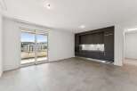 Experience modern living in this spacious apartment featuring a sleek, dark-toned kitchen with integrated appliances and ample cabinet space.