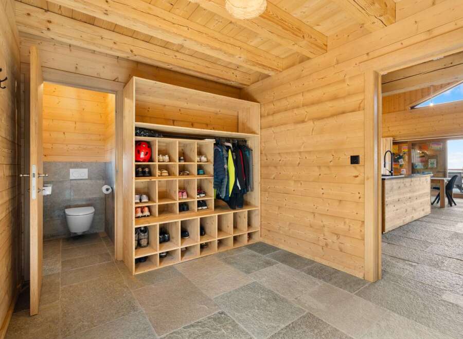 Discover this charming mountain retreat featuring a well-organized entryway with a spacious shoe rack and ample storage for outerwear.
