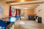 Experience rustic charm in this beautifully appointed wooden cabin, featuring a spacious dining area with dark tabletops and comfortable seating.