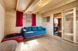 Experience rustic charm in this cozy wooden cabin, featuring a plush blue sofa perfect for relaxation.