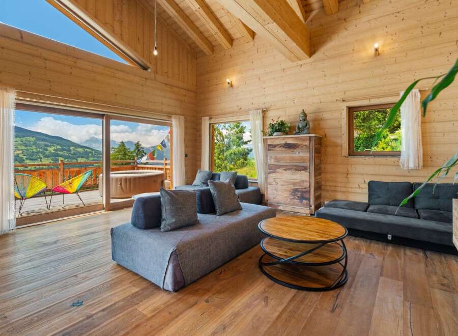 Experience breathtaking mountain views from this stunning wooden chalet living room.