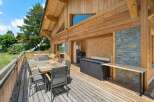 Enjoy outdoor living on this spacious wooden deck, complete with a dining set and a relaxing hot tub.