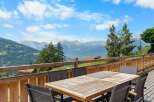 Enjoy breathtaking mountain views from this stunning property's expansive wooden deck, perfect for al fresco dining or simply soaking in the scenery.