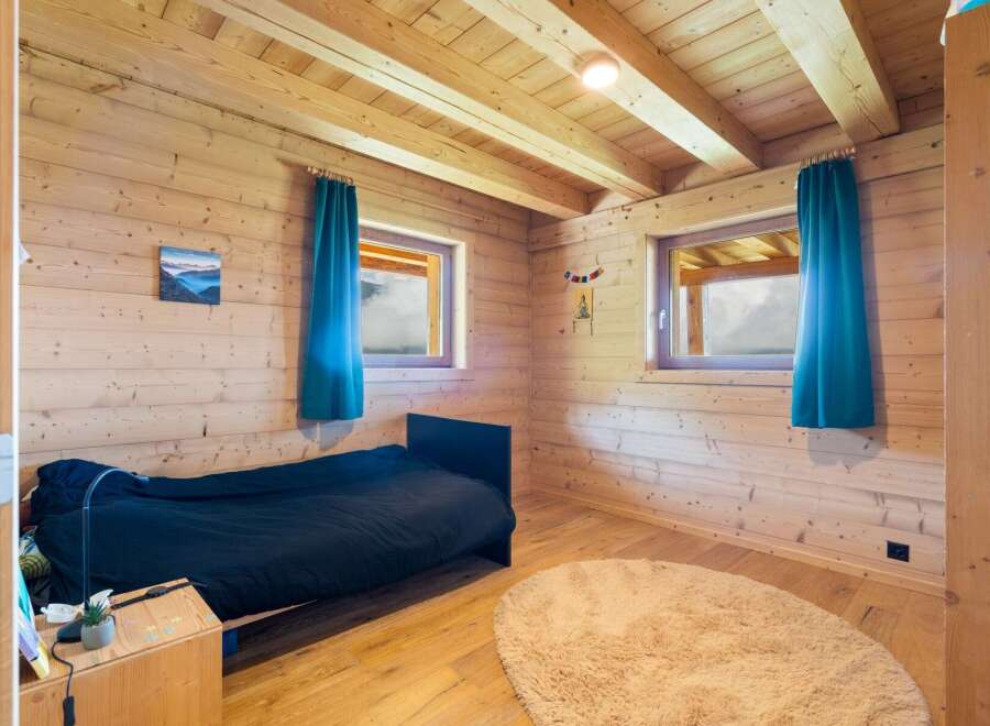 Experience cozy mountain living in this charming wooden cabin bedroom.
