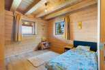 Experience cozy living in this charming wooden cabin bedroom, featuring a comfortable bed with playful Tarzan-themed bedding and a Simba pillow.