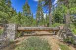Discover the exclusive 'Hidden Lake' community, marked by this rustic log and stone entrance.