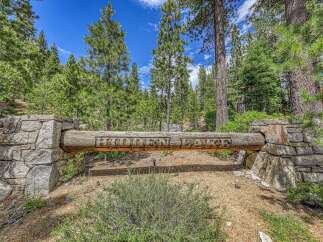 Discover the exclusive 'Hidden Lake' community, marked by this rustic log and stone entrance.