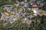 Experience luxury living in this stunning aerial view of a mountain estate featuring multiple modern homes nestled amongst lush pine trees.