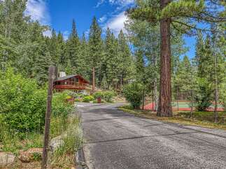 Nestled amidst towering pine trees, this stunning property offers a private oasis with a beautiful wooden home and a dedicated tennis court.
