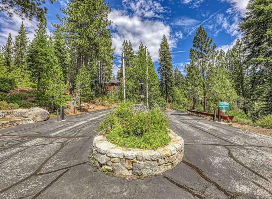Discover the exclusive entrance to Hidden Lake, a private community nestled amidst towering pine trees.