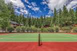 Enjoy outdoor recreation with this private tennis court, nestled amidst a lush forest setting.