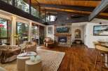 Experience luxurious mountain living in this stunning home featuring a grand stone fireplace and vaulted wood beam ceilings.