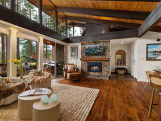 Experience luxurious mountain living in this stunning home featuring a grand stone fireplace and vaulted wood beam ceilings.