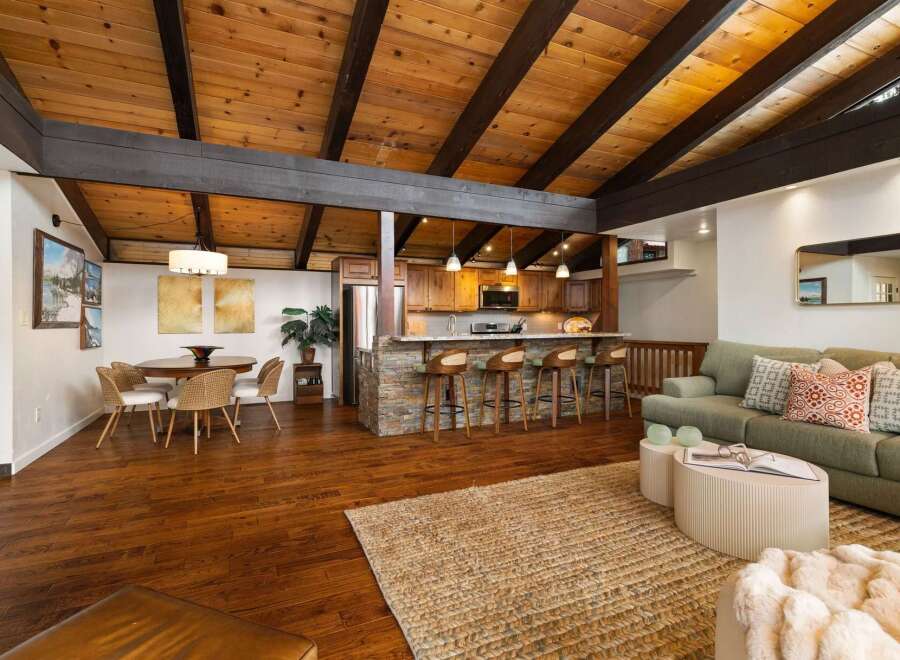Experience open-concept living with a stunning vaulted wood-beamed ceiling and a modern kitchen island perfect for entertaining.