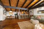 Experience open-concept living with a stunning vaulted wood-beamed ceiling and a modern kitchen island perfect for entertaining.