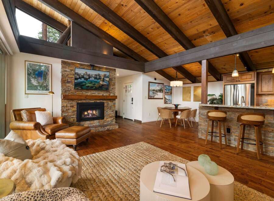 Experience rustic charm and modern comfort in this stunning living space, featuring a magnificent stone fireplace as the centerpiece.