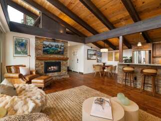 Experience rustic charm and modern comfort in this stunning living space, featuring a magnificent stone fireplace as the centerpiece.