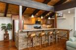Experience rustic charm in this kitchen featuring a stone-accented island with granite countertops, perfect for casual dining and entertaining.