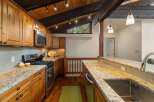 This stunning kitchen boasts beautiful natural wood cabinetry and a striking granite countertop that extends into a breakfast bar.