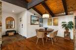 Experience rustic charm in this dining area featuring a warm wooden table and woven chairs, perfect for intimate gatherings.
