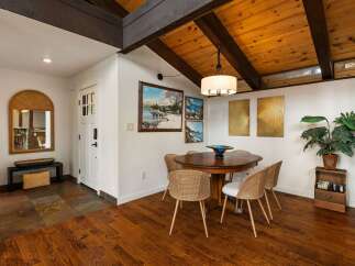 Experience rustic charm in this dining area featuring a warm wooden table and woven chairs, perfect for intimate gatherings.