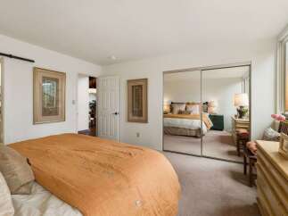 This inviting bedroom features a large bed with a warm orange comforter, perfect for cozy nights.