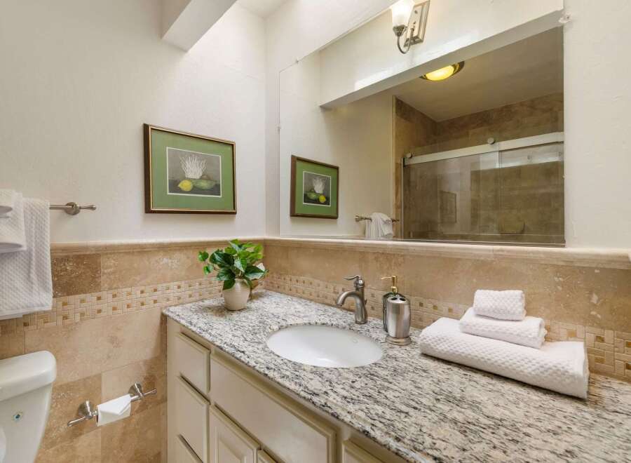 This beautifully appointed bathroom features a spacious vanity with a granite countertop and an undermount sink, perfect for your morning routine.