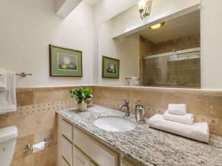 This beautifully appointed bathroom features a spacious vanity with a granite countertop and an undermount sink, perfect for your morning routine.