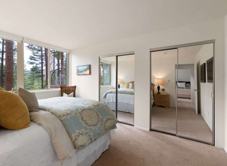 Experience serene living in this charming bedroom, featuring a comfortable bed adorned with plush pillows and a beautiful patterned duvet.