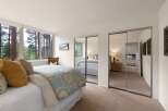 Experience serene living in this charming bedroom, featuring a comfortable bed adorned with plush pillows and a beautiful patterned duvet.