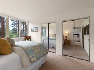 Experience serene living in this charming bedroom, featuring a comfortable bed adorned with plush pillows and a beautiful patterned duvet.