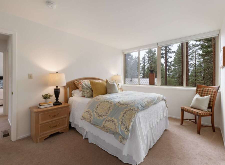 Experience serene living in this charming bedroom, featuring a comfortable queen-size bed adorned with a beautiful floral comforter.