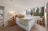 Experience serene living in this charming bedroom, featuring a comfortable queen-size bed adorned with a beautiful floral comforter.