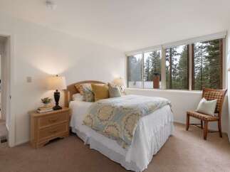 Experience serene living in this charming bedroom, featuring a comfortable queen-size bed adorned with a beautiful floral comforter.