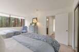 Experience serene living with this spacious bedroom featuring two comfortable beds, perfect for families or guests.