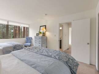 Experience serene living with this spacious bedroom featuring two comfortable beds, perfect for families or guests.