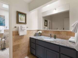 This charming bathroom features a spacious vanity with a granite countertop and a large mirror, perfect for your morning routine.
