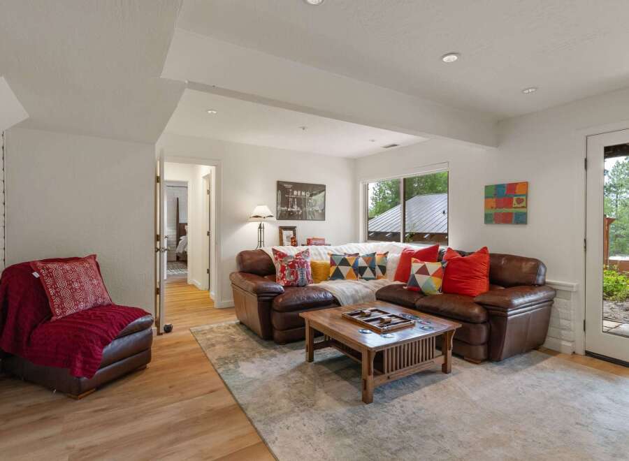 Step into this inviting living room featuring a plush leather sectional sofa adorned with colorful throw pillows, perfect for cozy gatherings.