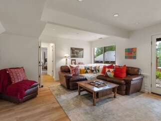 Step into this inviting living room featuring a plush leather sectional sofa adorned with colorful throw pillows, perfect for cozy gatherings.