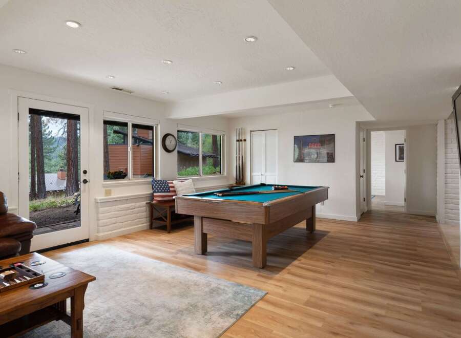 This inviting basement living area features a spacious pool table, perfect for entertainment and gatherings.