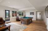 This inviting basement living area features a spacious pool table, perfect for entertainment and gatherings.