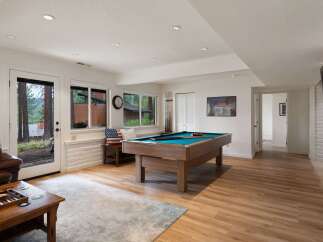 This inviting basement living area features a spacious pool table, perfect for entertainment and gatherings.