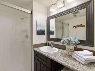 This modern bathroom features a sleek glass-enclosed shower with white tiled walls, perfect for a refreshing start to your day.