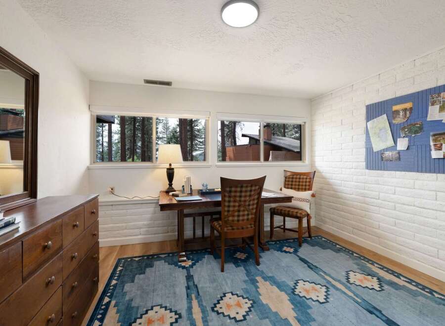 This home office features a rustic wooden desk with a plaid chair, perfect for a productive workday.