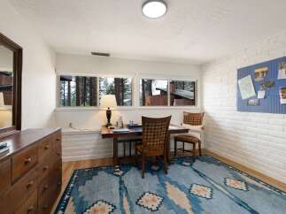 This home office features a rustic wooden desk with a plaid chair, perfect for a productive workday.